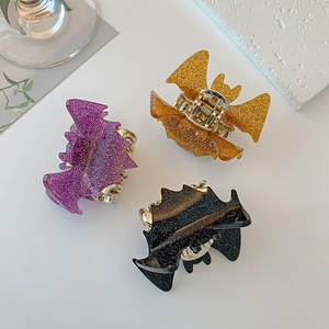 Glittery bat hair claws in purple, gold, and black for Halloween fashion styles