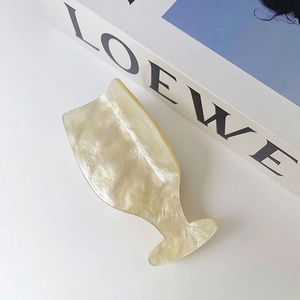 Close-up of elegant wine glass shaped hair claw clip in shimmering pearl white acetate