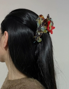 Detailed view of a vintage butterfly hair claw clip with acetate texture and gold edges