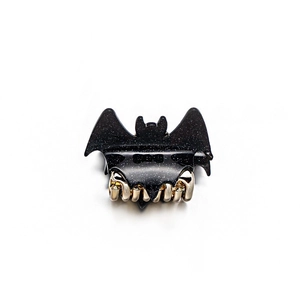 Gothic bat-shaped hair claw clip with black silver glitter resin and gold metal teeth