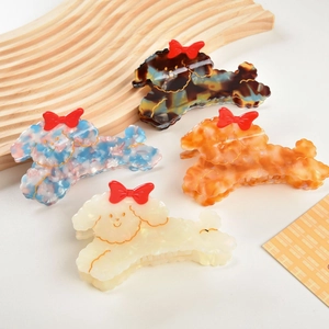 Set of four poodle-shaped cellulose acetate hair claws with red bows in marble colors
