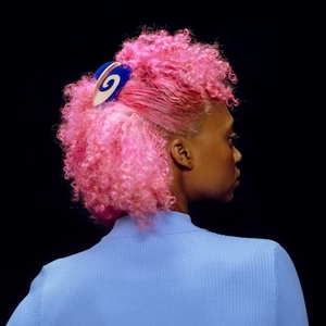 Blue and white bicolor acetate hair claw with swirl pattern on pink curly hair