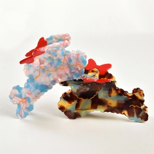 Detail view of acetate puppy hair claws with marble blue and tortoise shell textures