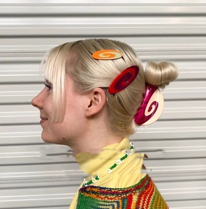 Detail showing colorful acetate hair clips with spiral texture on a female model