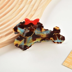 Detail of poodle shaped hair claw clip made of tortoiseshell acetate with blue accents