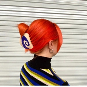 Detailed view of a blue and white swirl acetate hair claw clip styled on orange hair
