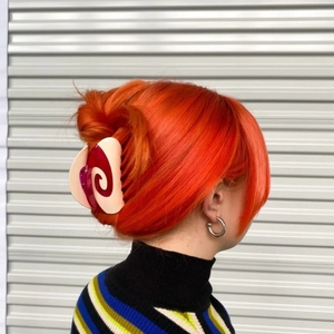 Detail of macaron swirl acetate hair claw clip showing dual-color design on hair