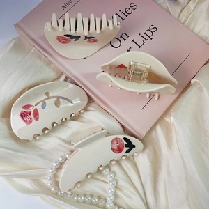 Set of four cream-colored acetate hair claws with red roses and pearls on silk fabric