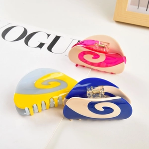 Three large matte hair claws with spiral patterns in assorted macaron color combinations