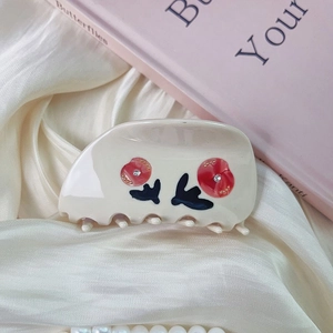 Detailed view of handmade rose hair claw with acetate finish and sparkling rhinestone inlay