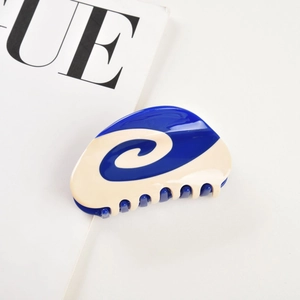 Detailed view of bicolor blue and cream acetate hair claw clip with spiral texture pattern