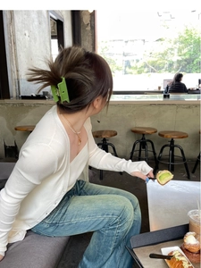 Grass green matte large acetate hair claw clip styled on a model in a cafe setting
