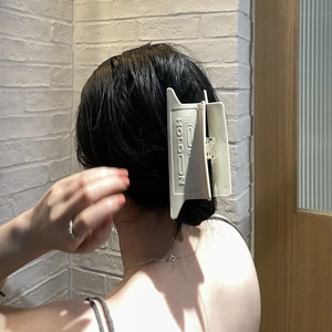 Minimalist cream rectangle hair claw clip with HOLDON relief on long matte acetate finish