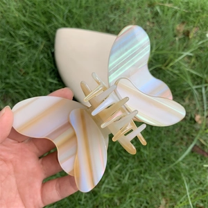 Detail of large iridescent acetate butterfly hair claw clip with pearly white finish