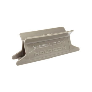Macro detail of khaki acetate claw clip with HOLDON engraving on white background