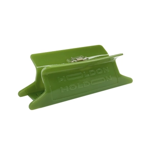 Detail view of a grass green cellulose acetate hair claw clip with HOLDON embossed lettering