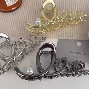 Detail von Metall-Haarklammern mit Love-Schriftzug und Perlen in Gold und Silber