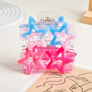 Detail of pink and blue gradient star-shaped hair claws on a decorative tray