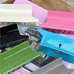 Colorful rectangular acetate hair claws with HOLDON relief design in five vibrant colors