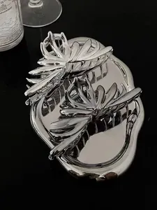Close-up of polished silver metal shark hair clips with hollow floral design
