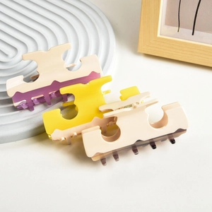 Three acetate hair claws with geometric hollow design in cream purple and brown shades