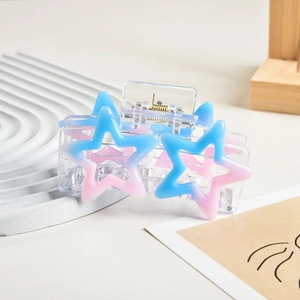 Detail of a Y2K star hair claw clip with blue-pink gradient on a white tray