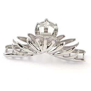Macro shot of large silver metal hair claw featuring a radiant floral petal design