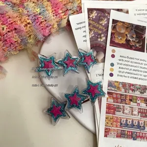 Détail de barrettes étoiles en deux pièces avec résine pailletée bleue et rose