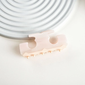 Detail view of pink cream acetate claw clip with marbled texture and geometric cutout