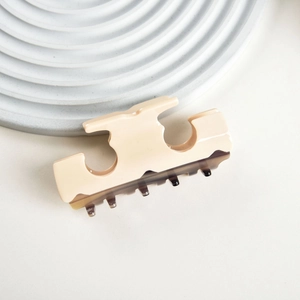 Detail view of T-shaped acetate hair claw clip with creamy top and tortoiseshell base