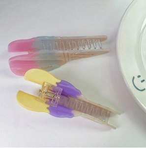 Dettagli macro delle pinze per capelli in acetato sfumato con scritte dorate eleganti
