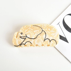 Détail d'une pince à cheveux en forme d'éléphant avec motif marbré crème et art au trait