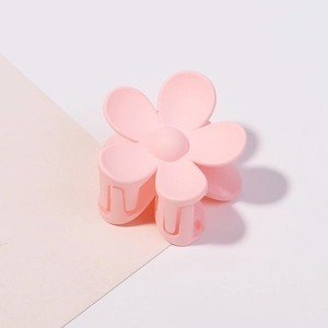 Dettaglio di una molletta per capelli a fiore rosa opaco con struttura a pettine fissa