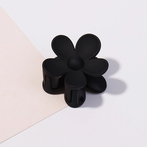 Macro di una piccola clip per capelli a fiore nero opaco con design a cinque petali