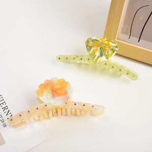 Detailed view of two acetate shell shark hair clips with sparkling colorful rhinestones