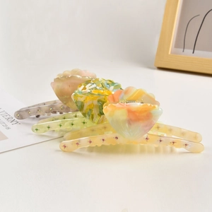 Three-piece floral shell rhinestone claw clips in pearlescent pink, green, and orange