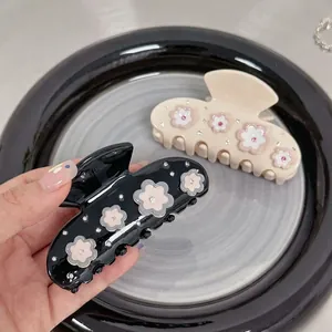 Elegant floral acetate hair claw clip with rhinestones and 3D petals in black and cream