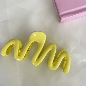 Vibrant yellow wavy large hair claw clip in a glossy cream finish for women