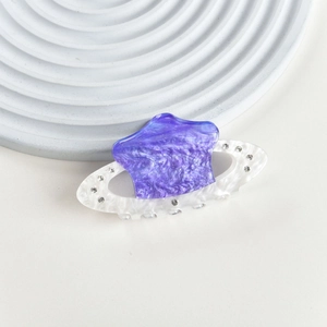Close-up of Saturn-shaped hair claw with purple marble resin and sparkling rhinestones