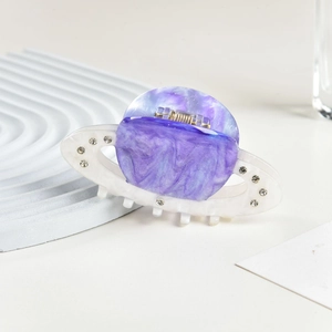 Detail of Saturn-shaped acetic acid hair claw clip with purple marble pattern and rhinestones