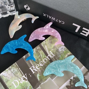 Set of four dolphin-shaped acrylic hair clips in marble texture on fashion book