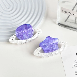 Detailed view of two purple marble acetate hair claws with sparkling rhinestone accents