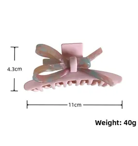 Dettaglio molletta a fiocco in acetato marmorizzato rosa 11cm con finitura lucida