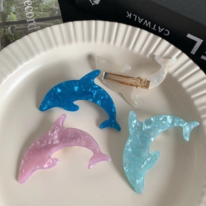 Cute dolphin-shaped acetate hair clips in multiple colors with gold metal duckbill grip
