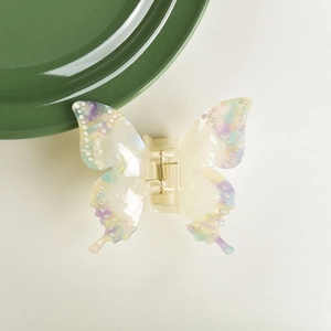 Macro detail of acetate butterfly hair claw with rhinestone accents and gold spring
