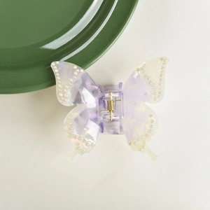 Detailed macro view of butterfly hair claw with violet marble pattern and rhinestones