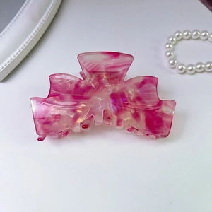 Detail view of the pink marble textured acetate butterfly hair claw clip for women