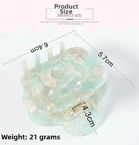 Detailed size view of a floral acetate hair claw with mint green marble texture and weight