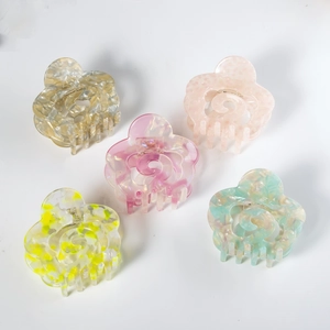 Set of five hollow flower acetate hair claws in pastel Morandi colors on white background