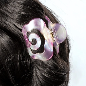Iridescent purple acetate flower hair claw clip shown on long dark hair for women